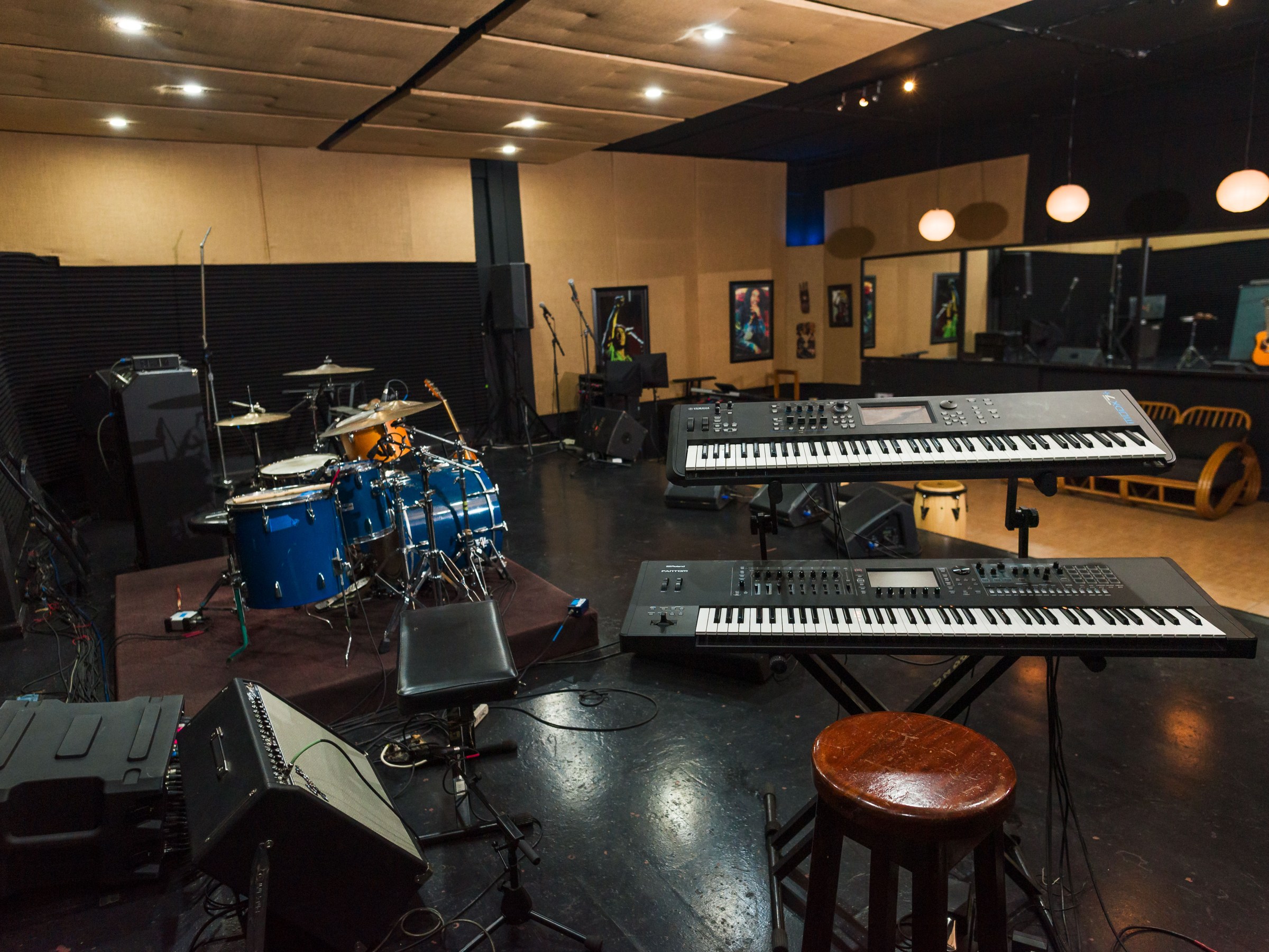 Music studio with drum set, keyboards, and amplifiers.